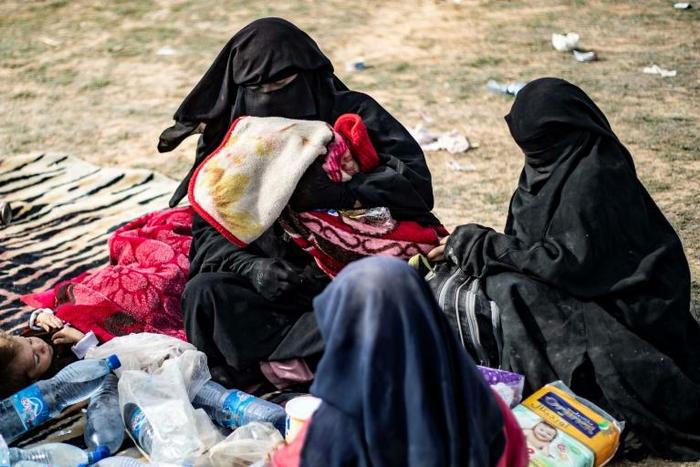 Dorothee Maquere, wife of French jihadist Jean-Michel Clain, sits with four of her five children at a screening area in the eastern Syrian province of Deir Ezzor on March 5, 2019 after fleeing the IS group's holdout of Baghouz