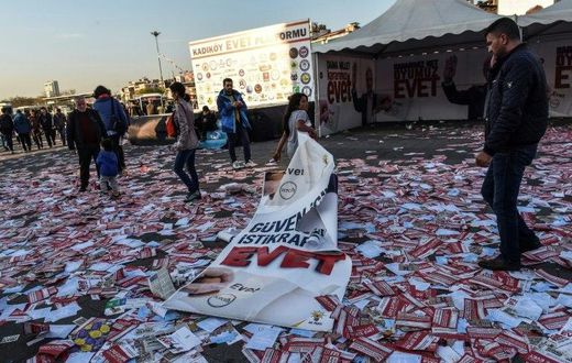 A girl drags a banner reading "yes" across piles of "yes" leaflets in the Kadikoy district of Istanbul