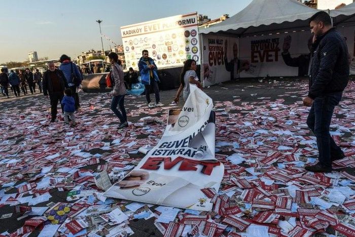 A girl drags a banner reading "yes" across piles of "yes" leaflets in the Kadikoy district of Istanbul