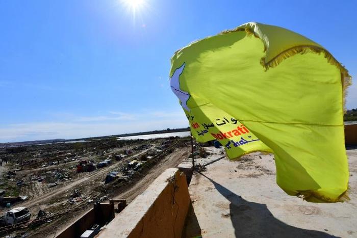 An SDF flag flies over a building in what had been the Islamic State group's last territorial bastion of Baghouz in eastern Syria
