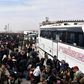 Syrian families, fleeing from various eastern districts of Aleppo, queue to get onto buses on November 29, 2016