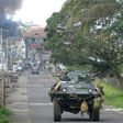 A Philippine Marines truck and armoured personnel carrier speed away as black smoke billows from burning houses after military helicopters fired rockets at militant positions in Marawi on the southern island of Mindanao
