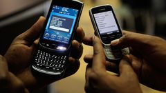 File image of mobile phone users engaged on their handsets
