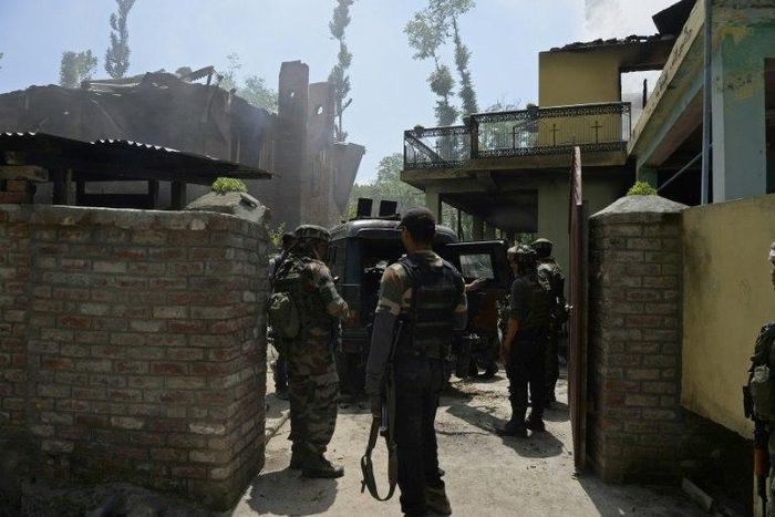Indian army soldiers stand next to a burning house where two Kashmiri rebels were killed during a gunfight in the Tral area south of Srinagar on May 27, 2017
