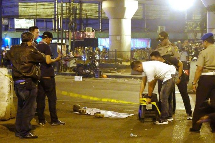 Police officers and investigators work at the scene of a bomb blast that killed at least one person near a bus terminal in Jakarta, on May 24, 2017