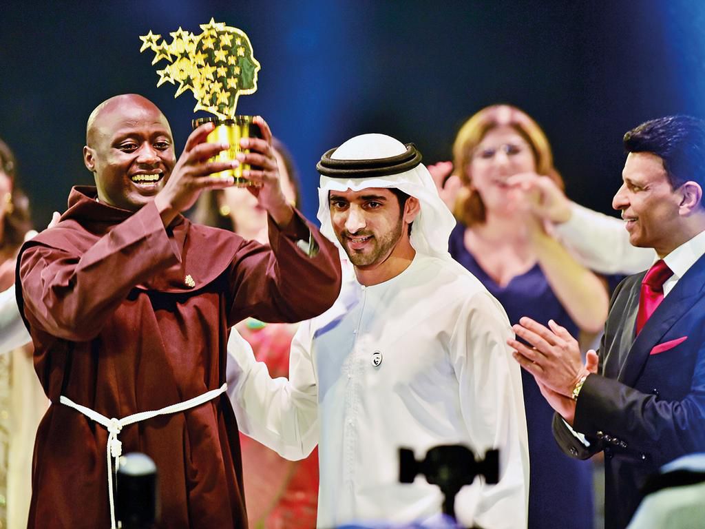 Shaikh Hamdan presents the Best teacher award to Peter Tabichi, a Maths and Physics teacher from Kenya, as Sunny Varkey, founder of the GESF, looks on. (Gulf News)