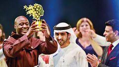 Shaikh Hamdan presents the Best teacher award to Peter Tabichi, a Maths and Physics teacher from Kenya, as Sunny Varkey, founder of the GESF, looks on. (Gulf News)