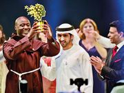 Shaikh Hamdan presents the Best teacher award to Peter Tabichi, a Maths and Physics teacher from Kenya, as Sunny Varkey, founder of the GESF, looks on. (Gulf News)