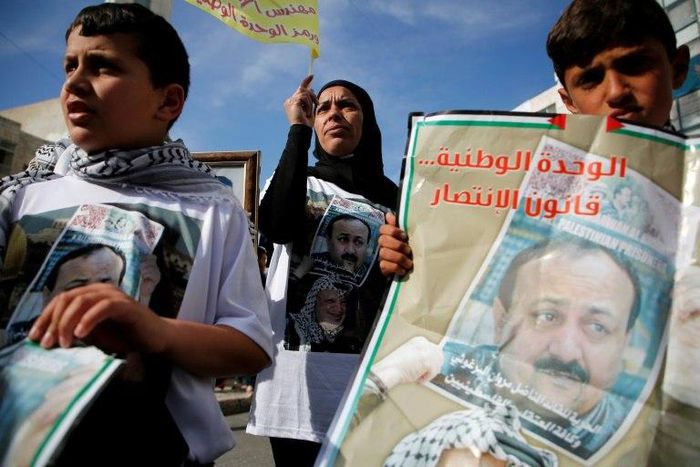 Palestinians hold portraits of Palestinian leader and prominent prisoner Marwan Barghouti, during a rally in the West Bank city of Ramallah in support of prisoners on hunger strike in Israeli jails on April 24, 2017