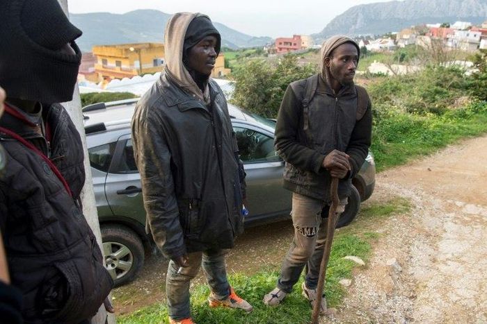 Migrants stand on the outskirts of the Moroccan city of Fnidek on February 18, after forcing their way through a border fence between Morocco and the tiny Spanish enclave of Ceuta