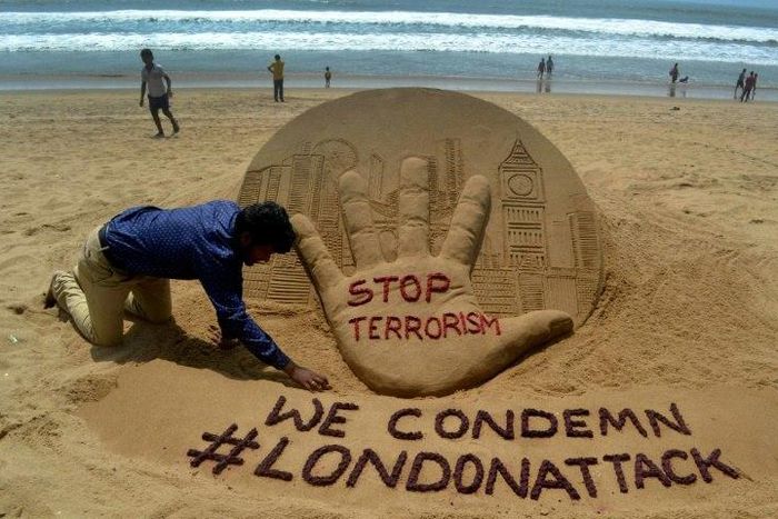 Indian sand artist Sudarsan Pattnaik creates a sculpture on Puri Beach on the Bay of Bengal the day after the London attack