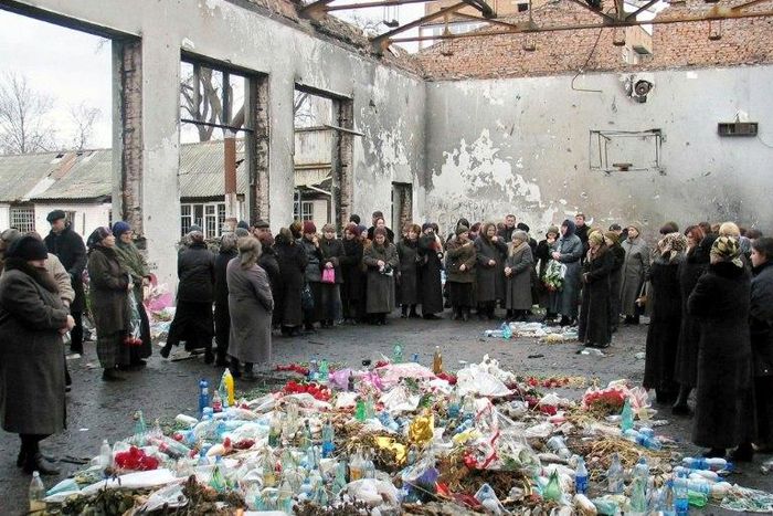 Friends and relatives of victims killed in the 2004 Beslan school hostage massacre gather on March 3, 2005 in the remains of the school in North Ossetia for a minute's silence to commemorate the six-month anniversary of the tragedy
