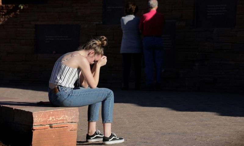 Maren Strother, 16, rests her head on her hands at a vigil in Littleton, Colorado to the April 20, 1999 mass shooting at Columbine High School