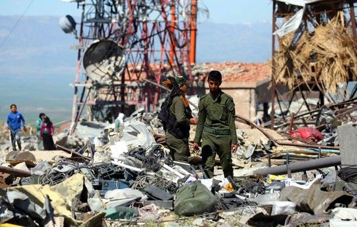 Fighters from the Kurdish People's Protection Units (YPG) and Kurdish police, known as the Asayish, visit the site of Turkish airstrikes near northeastern Syrian Kurdish town of Derik, known as al-Malikiyah in Arabic, on April 25, 2017
