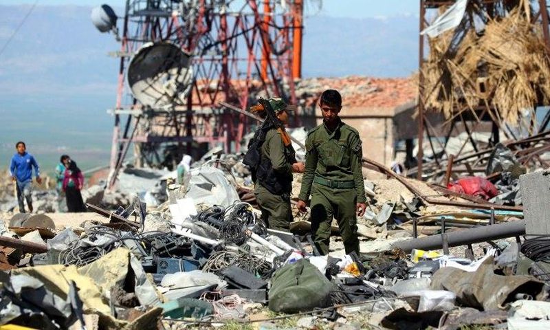 Fighters from the Kurdish People's Protection Units (YPG) and Kurdish police, known as the Asayish, visit the site of Turkish airstrikes near northeastern Syrian Kurdish town of Derik, known as al-Malikiyah in Arabic, on April 25, 2017