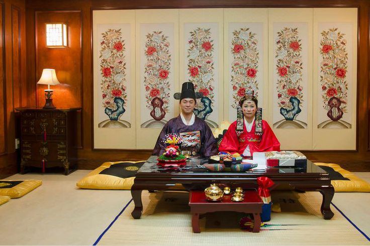 A korean couple pose for pictures at their wedding ceremony