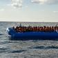 Migrants and refugees seated on a rubber boat wait to be evacuated during a rescue operation on November 4, 2016 off the Libyan coast
