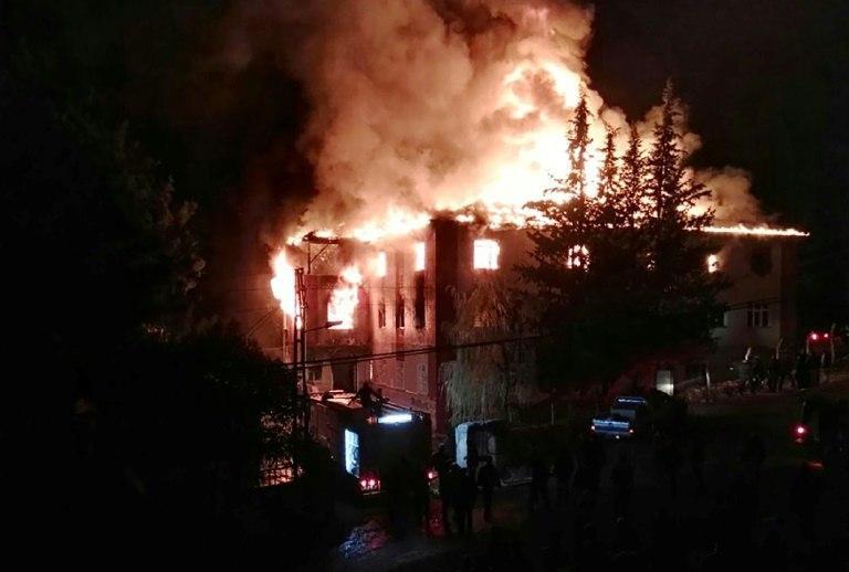 Flames are seen as firefighters try to control a fire at a school in Adana, southern Turkey, on November 29, 2016 that killed 12 people