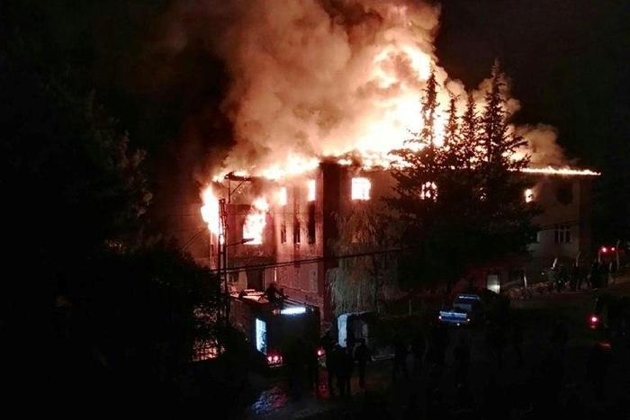 Flames are seen as firefighters try to control a fire at a school in Adana, southern Turkey, on November 29, 2016 that killed 12 people