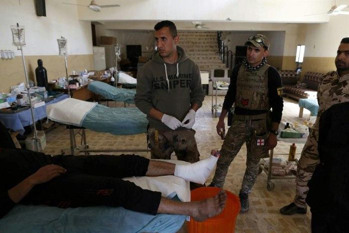 Members of the Iraqi forces tend to a civilian who was injured by Islamic State (IS) group jihadists at a school turned hospital in western Mosul on March 24, 2017