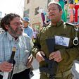 A Jewish settler dressed in military fatigues wears a portrait of Elor Azaria, an Israeli soldier who shot dead a wounded Palestinian assailant, during a parade marking the Jewish holiday of Purim in Hebron on March 12, 2017