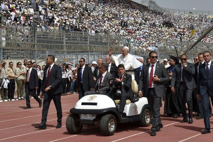 Pope Francis is surrounded by security before the start of a mass on April 29, 2017 at a stadium in Cairo
