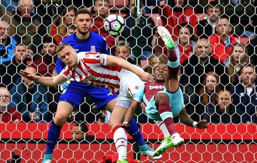 West Ham United's Andre Ayew (R) tries an overhead shot, which is saved by Stoke City's Jack Butland during their match in Stoke-on-Trent, central England on April 29, 2017