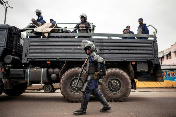 A policeman walks in front of a police truck as the Congolese capital Kinshasa is gripped by a strike on October 19, 2016