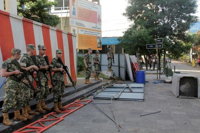 Police guard the area around Government House in Asuncion, after demonstrators set fire to the Congress building during protests over a constitutional amendment