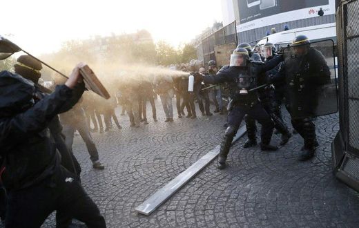 Anti-fascist demonstrators clash with police in Paris after the first round of voting in the country's presidential elections. Centrist Emmanuel Macron and far-right leader Marine Le Pen will contest the May 7 runoff, according to early projections