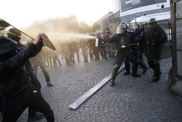 Anti-fascist demonstrators clash with police in Paris after the first round of voting in the country's presidential elections. Centrist Emmanuel Macron and far-right leader Marine Le Pen will contest the May 7 runoff, according to early projections