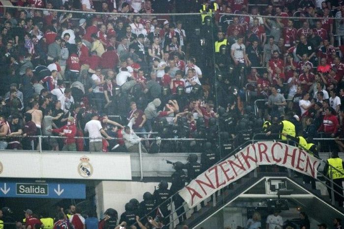 Riot police clash with Bayern fans in the tribunes during the UEFA Champions League quarter-final match against Real Madrid at the Santiago Bernabeu stadium in Madrid in Madrid on April 18, 2017