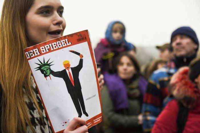 A young woman holds the last edition of "Der Spiegel" magazine with a cover designed by Edel Rodriguez, as she protests against the travel ban imposed by US President Donald Trump, on February 4, 2017, in Berlin