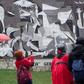 Tourists take pictures of a mural depicting Pablo Picasso's painting "Guernica" in the northern Spanish town on the 80th aniversary of a Nazi bombing raid that killed hundreds