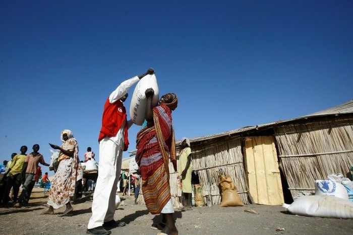 South Sudanese refugees collect aid food at a "Refugee Waiting Centre" in Al-Eligat area along the border in Sudan's White Nile state on February 27, 2017