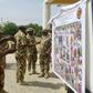 Soldiers take pictures of a banner with the Nigerian army's list of most wanted Boko Haram Islamists, in Maiduguri, on November 21, 2016