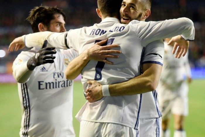 Real Madrid's forward Cristiano Ronaldo (C) is congratulated by teammate Karim Benzema (R) after scoring on February 11, 2017