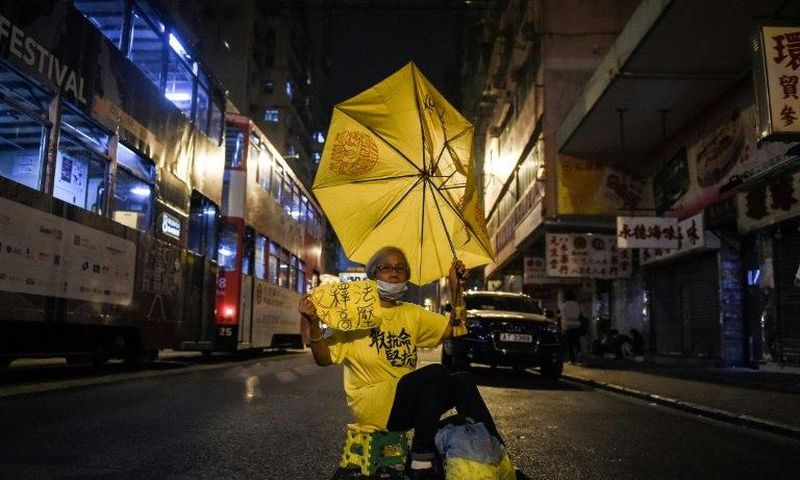A protester holds a yellow umbrella as she protests in Hong Kong, early on November 7, 2016