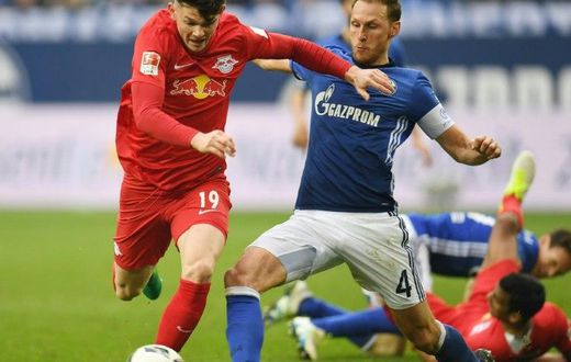 Schalke's defender Benedikt Hoewedes and Leipzig's midfielder Oliver Burke fight for the ball on April 23, 2017