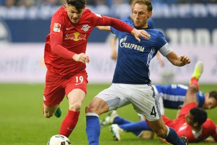 Schalke's defender Benedikt Hoewedes and Leipzig's midfielder Oliver Burke fight for the ball on April 23, 2017