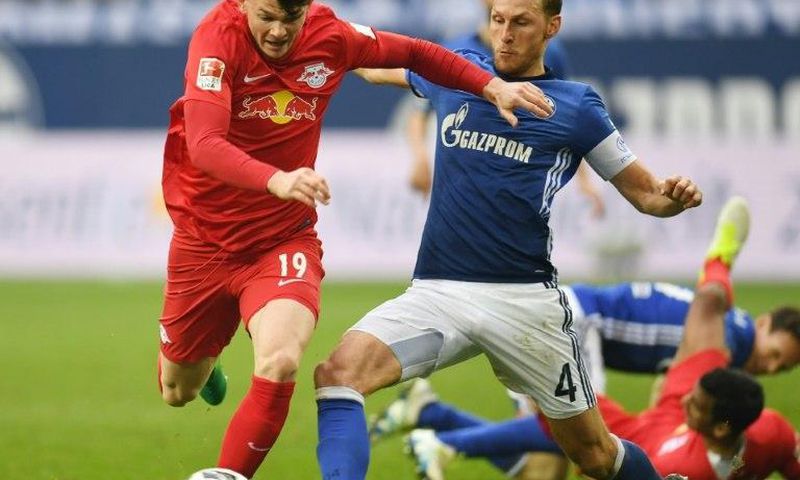Schalke's defender Benedikt Hoewedes and Leipzig's midfielder Oliver Burke fight for the ball on April 23, 2017