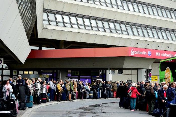 Passengers queue for bus transport during a wage strike by ground staff at Berlin's Tegel airport on March 10, 2017