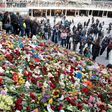 People place flowers on April 9, 2017 on the steps at Sergels Torg plaza in Stockholm close to the point where a truck drove into a department store in Stockholm, Sweden