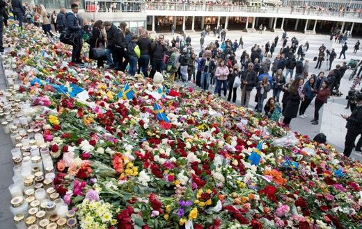People place flowers on April 9, 2017 on the steps at Sergels Torg plaza in Stockholm close to the point where a truck drove into a department store in Stockholm, Sweden