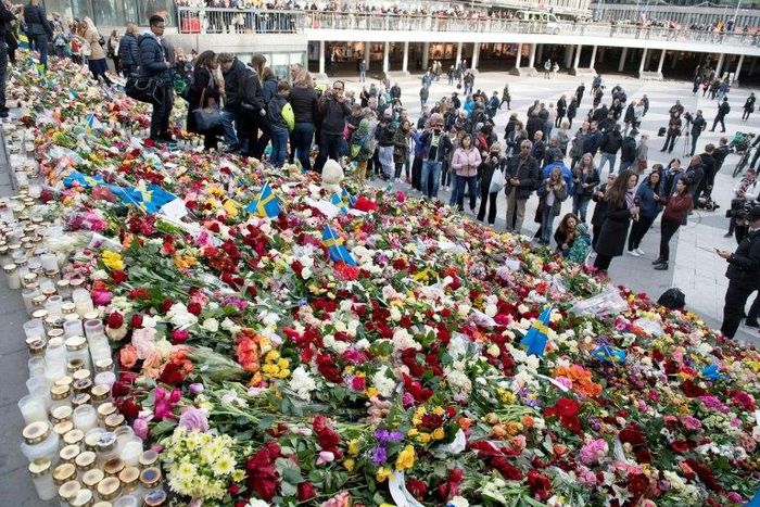People place flowers on April 9, 2017 on the steps at Sergels Torg plaza in Stockholm close to the point where a truck drove into a department store in Stockholm, Sweden