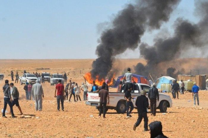 Smoke billows during clashes between Tunisian protesters and security forces outside the El Kamour oil and gas pumping station, in the southern state of Tataouine, on May 22, 2017