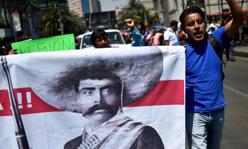 Teachers carrying a banner depicting Mexican revolutionary leader Emiliano Zapata shout slogans during a protest in Mexico City