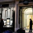 French police officers stand guard in front of the entrance of the building where the offices of Swiss watchmaker Girard Perregaux are located on rue de la Paix, in central Paris, following a robbery on October 20, 2016