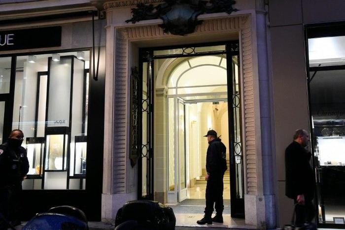 French police officers stand guard in front of the entrance of the building where the offices of Swiss watchmaker Girard Perregaux are located on rue de la Paix, in central Paris, following a robbery on October 20, 2016