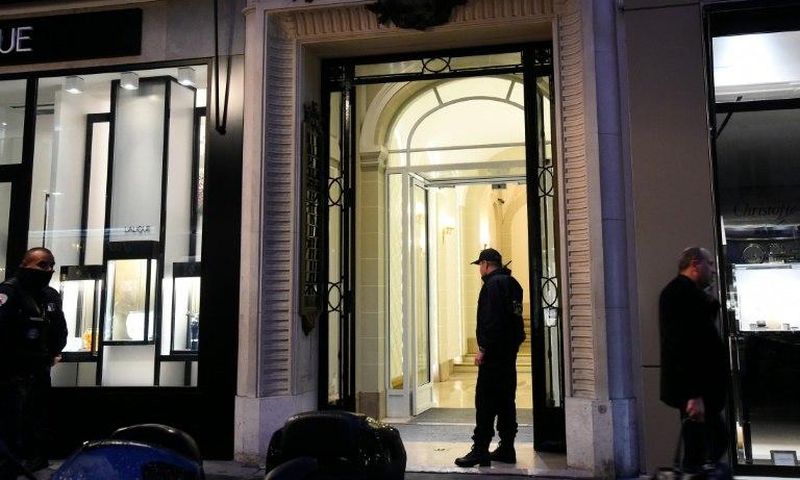 French police officers stand guard in front of the entrance of the building where the offices of Swiss watchmaker Girard Perregaux are located on rue de la Paix, in central Paris, following a robbery on October 20, 2016